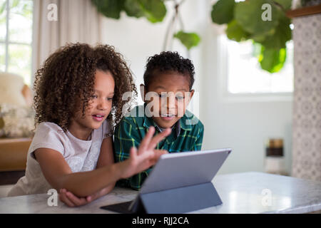 African American brother and sister playing together on digital tablet Stock Photo