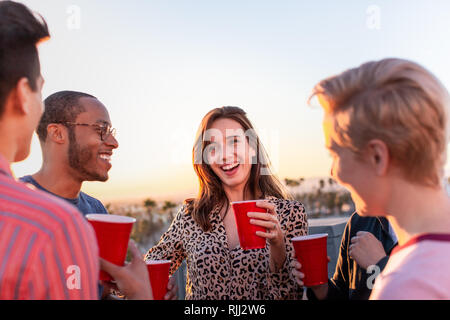 Group of friends gathering on a rooftop for a celebration Stock Photo