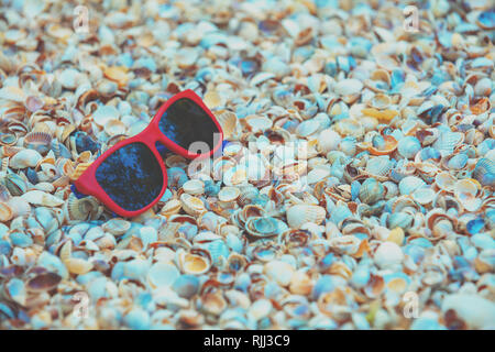 Beach scene. Sunglasses lying on sea shells Stock Photo