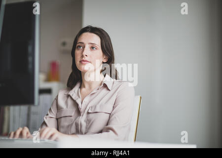 Female business executive working in an office on a desktop computer Stock Photo