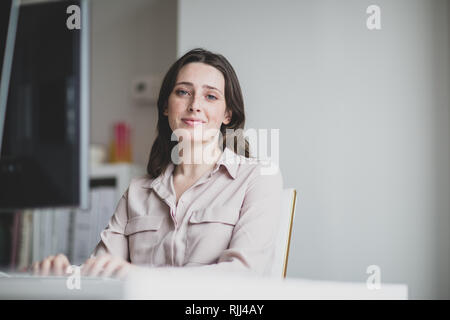 Portrait of a female business executive working in an office on a desktop computer Stock Photo
