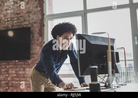 Male african american business executive standing and working on a desktop computer Stock Photo