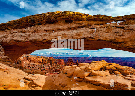 January 2019: Canyonlands National Park's Mesa Arch provides a beautiful sandstone frame for the snowcapped La Sal Mountains near Moab, Utah. Stock Photo