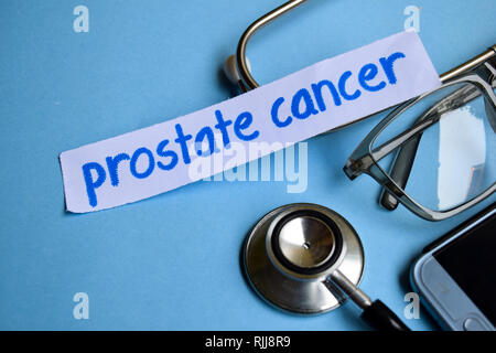 Conceptual image with Prostate cancer inscription with the view of stethoscope, eyeglasses and smartphone on the blue background. Medical Conceptual. Stock Photo