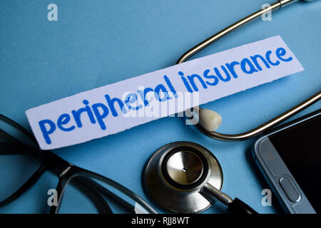 Conceptual image with Peripheral Insurance inscription with the view of stethoscope, eyeglasses and smartphone on the blue background. Medical Concept Stock Photo