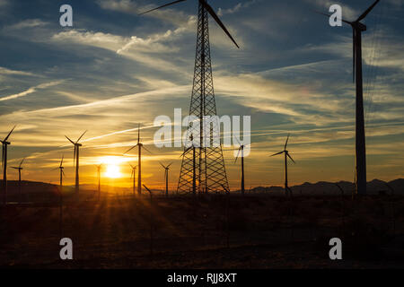 sunrise over valley with working wind turbines Stock Photo