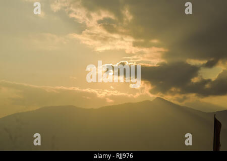 sky with clouds and sun. Storm clouds and orang sky. Sunlight rays in reflects clouds. Beautiful aerial view above clouds with sunset. Nature wallpape Stock Photo