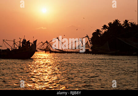 Chinese fishing nets line the mouth of the harbour at Fort Cochin, an old Portuguese town in Kerala. An ancient trading hub, Cochin has remnants of cu Stock Photo