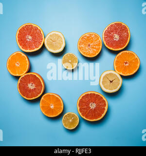 cut in half juicy citruses on a blue background which lined heart Stock Photo