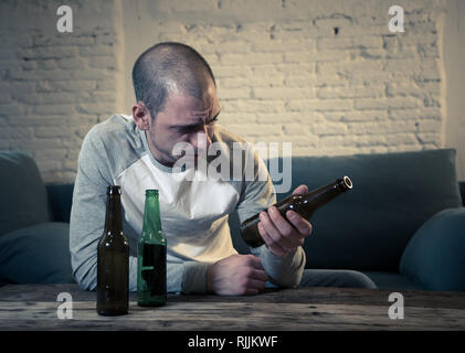 Young sad drunk men drinking beer and alcohol feeling wasted, lonely and desperate in pain and emotional stress. People and Alcohol abuse, addiction a Stock Photo