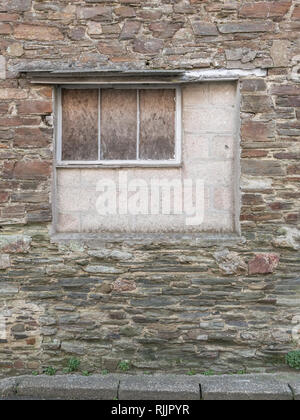 Partially bricked-up window in an outhouse building. Stock Photo