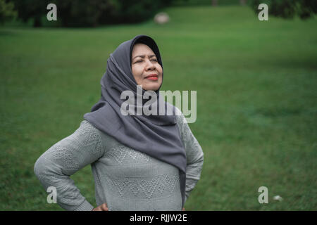 enior muslim woman relaxing taking deep breath and stretching Stock Photo