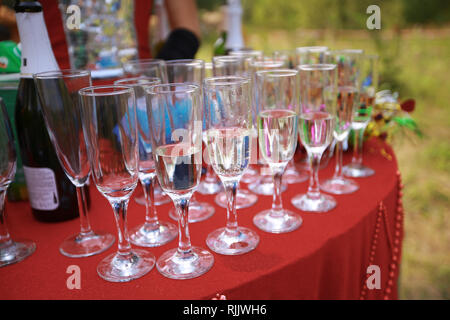 Table setting at a luxury wedding or another catered event. Glasses of champagne on a red table Stock Photo