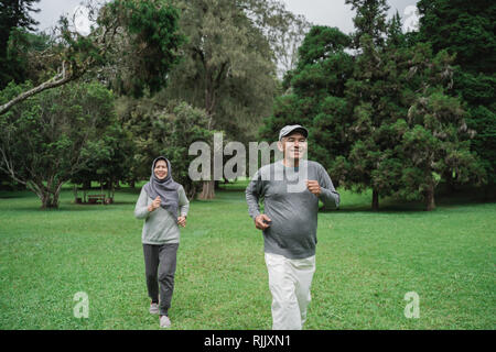 couple doing exercising by running in the garden  Stock Photo