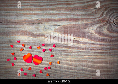 Valentine, wedding card background with two big and many small hearts on a plank of wood with a knot Stock Photo