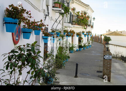 Mijas, Spain.A small street in Mijas, Spain with many hanging baskets filled with flowers. Stock Photo