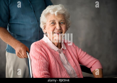 Senior woman being pushed in a wheelchair. Stock Photo