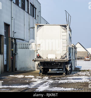 parked tank trailer at the door of a warehouse, outdoor exterior of a workplace Stock Photo