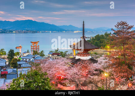 Miyajima Island, Hiroshima, Japan with temples on the Seto Inland Sea at dusk in the spring season. Stock Photo