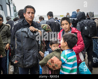 BERKASOVO, SERBIA - OCTOBER 17, 2015: Family of refugees, a man holding his children, waiting to cross the Croatia Serbia border, on the Balkans Route Stock Photo
