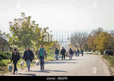 BERKASOVO, SERBIA - OCTOBER 17 2015: Refugees walking with heavy bags on the way to Croatia on the Croatian Serbian border, on the Balkans Route, duri Stock Photo