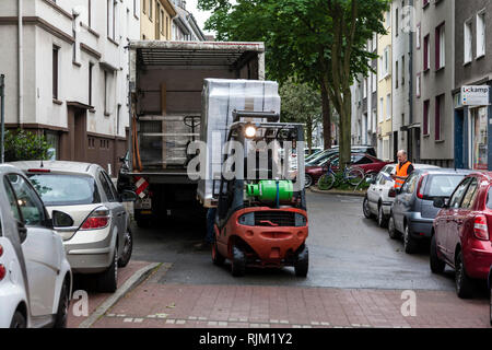 Truck is unloaded in a residential area with a forklift Stock Photo