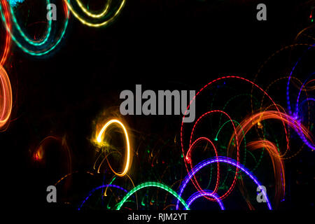 Bright rounded glowing splashes on black backdrop with copy space. Stock Photo