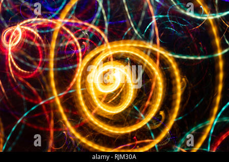 Close-up abstract glowing yellow spiral swirl on black background.  Stock Photo