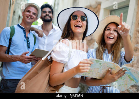 Happy group of friends tourists sightseeing in city on vacation Stock Photo