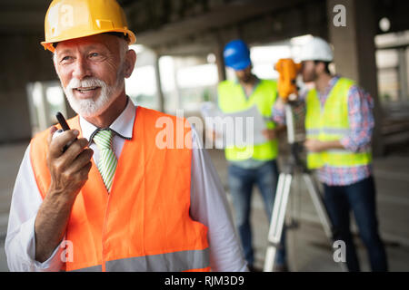 Confident team of architects and engineers working together on construction site Stock Photo