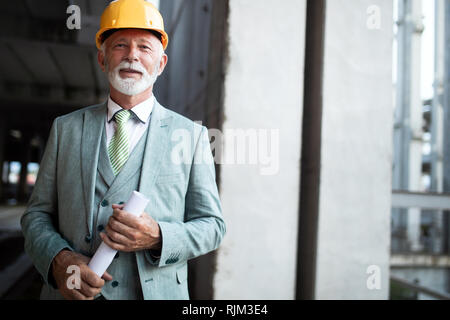 Portrait of an handsome senior engineer, architect, businessman on construction site Stock Photo
