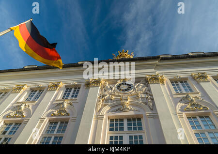 German flag waves against the blue sky in front of the Bundesstadt Bonn - Altes Rathaus, City Hall Government office on Markt square. Germany. Stock Photo