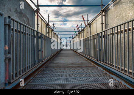 Pedestrian bridge of metal in the harbor as passage Stock Photo