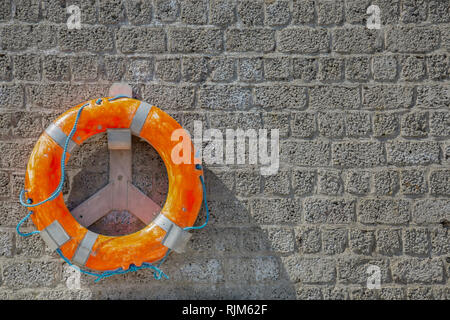 Rescue ring fixed on a Stone wall Stock Photo