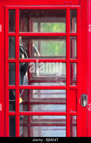 Detail of double red vintage english phone box, many small glass windows at door, interior view inside through it (copy space) Stock Photo