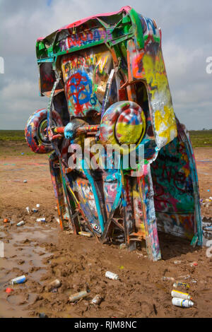 Cadillac Ranch is an art installation comprised of old Cadillacs half-buried, nose down, and spray painted daily by visitors near Amarillo, TX Stock Photo