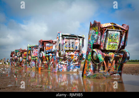 Cadillac Ranch is an art installation comprised of old Cadillacs half-buried, nose down, and spray painted daily by visitors near Amarillo, TX Stock Photo