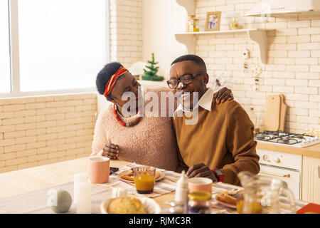 Positive nice couple sitting together in the kitchen Stock Photo