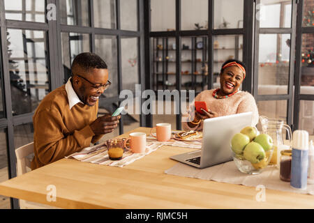Joyful afro American couple using modern technologies Stock Photo