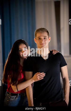 Young smiling couple. A young woman hugging her boyfriend from the back Stock Photo