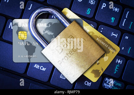 Golden padlock on top of credit or debit cards on computer keyboard. Concept of Internet security, data privacy, cybercrime prevention for online shop Stock Photo