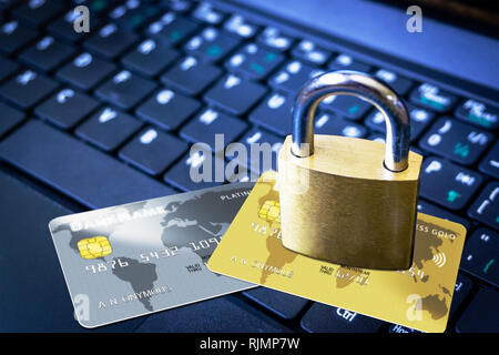 Golden padlock on top of fictitious credit cards on computer keyboard. Concept of Internet security, data privacy, cybercrime prevention for online sh Stock Photo