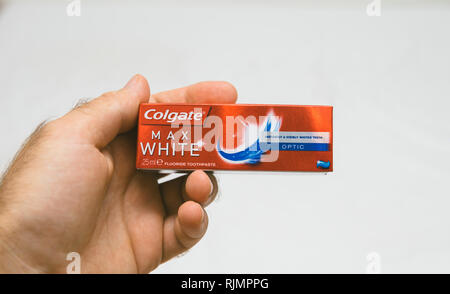 PARIS, FRANCE - JUL 27, 2018: Man holding Colgate small air security rules conformed travel toothpaste against white background Stock Photo