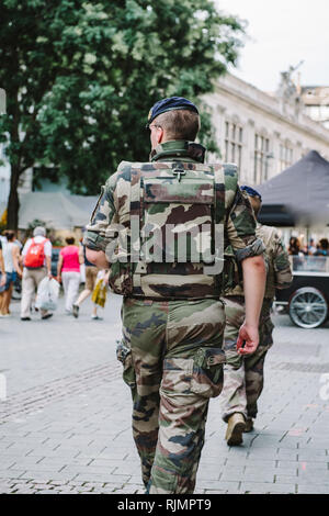 Rear view of unrecognizable male soldier VIGIPIRATE in camouflage uniform patrolling the French street of Strasbourg Stock Photo