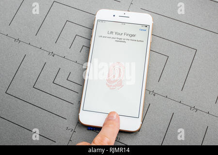 PARIS, FRANCE - SEP 26, 2016: Male hand holding New Apple iPhone 7 8 Plus after unboxing and testing by installing the app application software set fingerprint password on phone security privacy acces to the smartphone Stock Photo