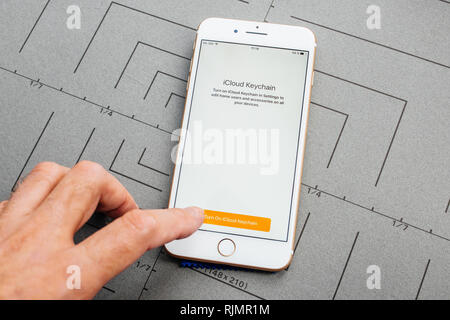 PARIS, FRANCE - SEP 26, 2016: Male hand holding New Apple iPhone 7 8 Plus smartphone after unboxing and testing by installing the app application software iCloud Keychain security password access Stock Photo