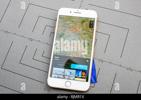 PARIS, FRANCE - SEP 26, 2016: Male hand holding New Apple iPhone 7 8 Plus smartphone after unboxing and testing by installing the app application software Apple Maps GPS flyover Paris France Stock Photo