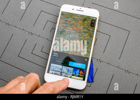 PARIS, FRANCE - SEP 26, 2016: Male hand holding New Apple iPhone 7 8 Plus smartphone after unboxing and testing by installing the app application software Apple Maps GPS flyover Paris France Stock Photo