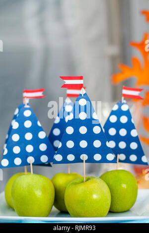 Green apples with blue paper sail. Sea time theme on the party's candy bar. Stock Photo