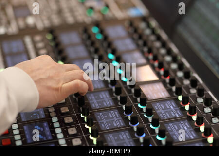 Sound engineer works on modern digital audio mixer at recording studio. Stock Photo